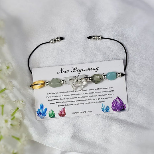 crystal bracelet with colorful beads on a card labeled new beginning against a white background.