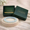 Blue beaded bracelet on a stand with 'Calminds' branded box in the background