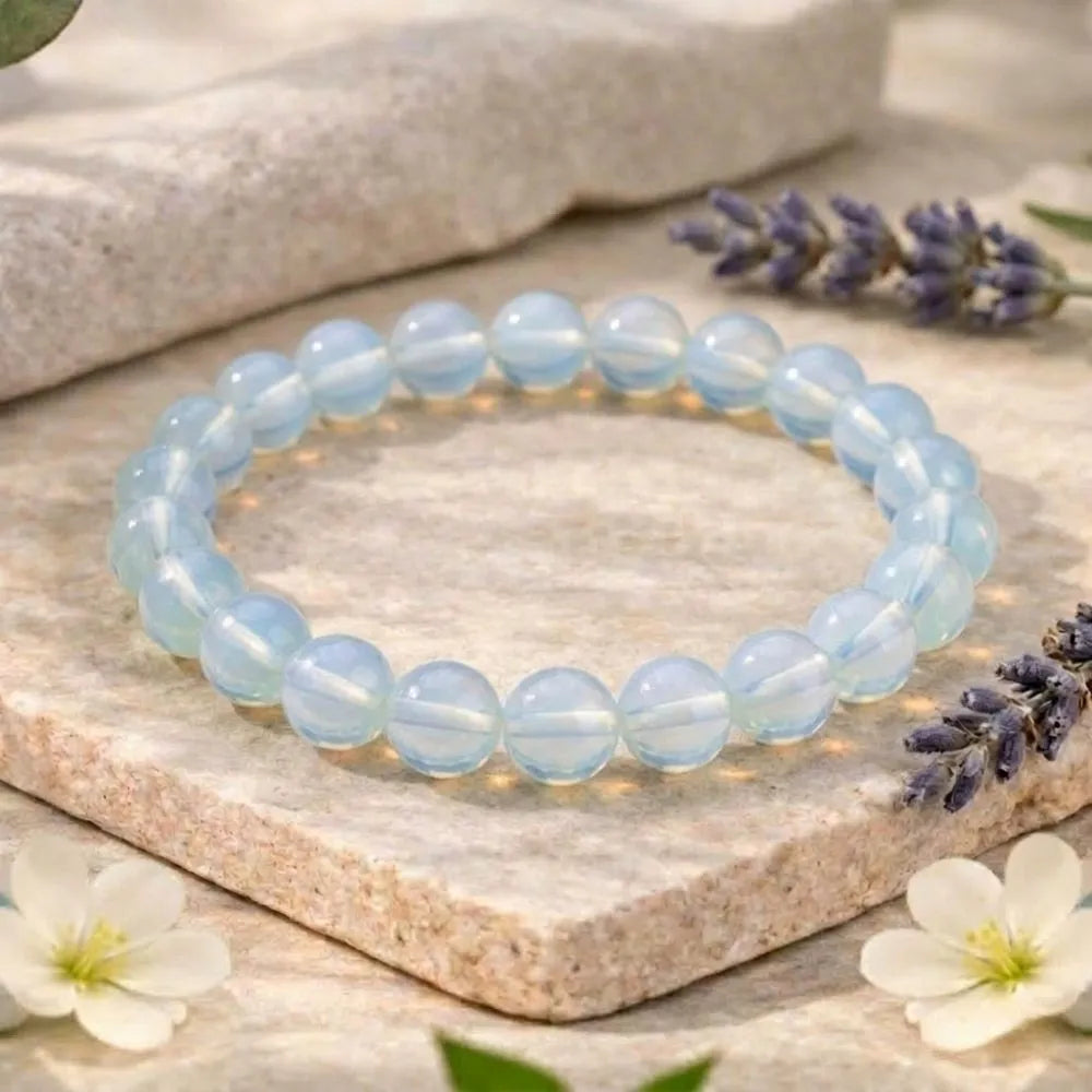 Blue beaded bracelet on a stone surface with lavender and flowers