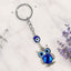 Keychain with blue owl and evil eye charm on a light background