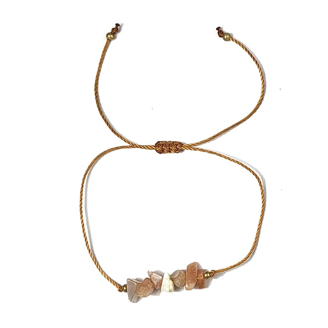 thread bracelet with peach stone beads on a white background
