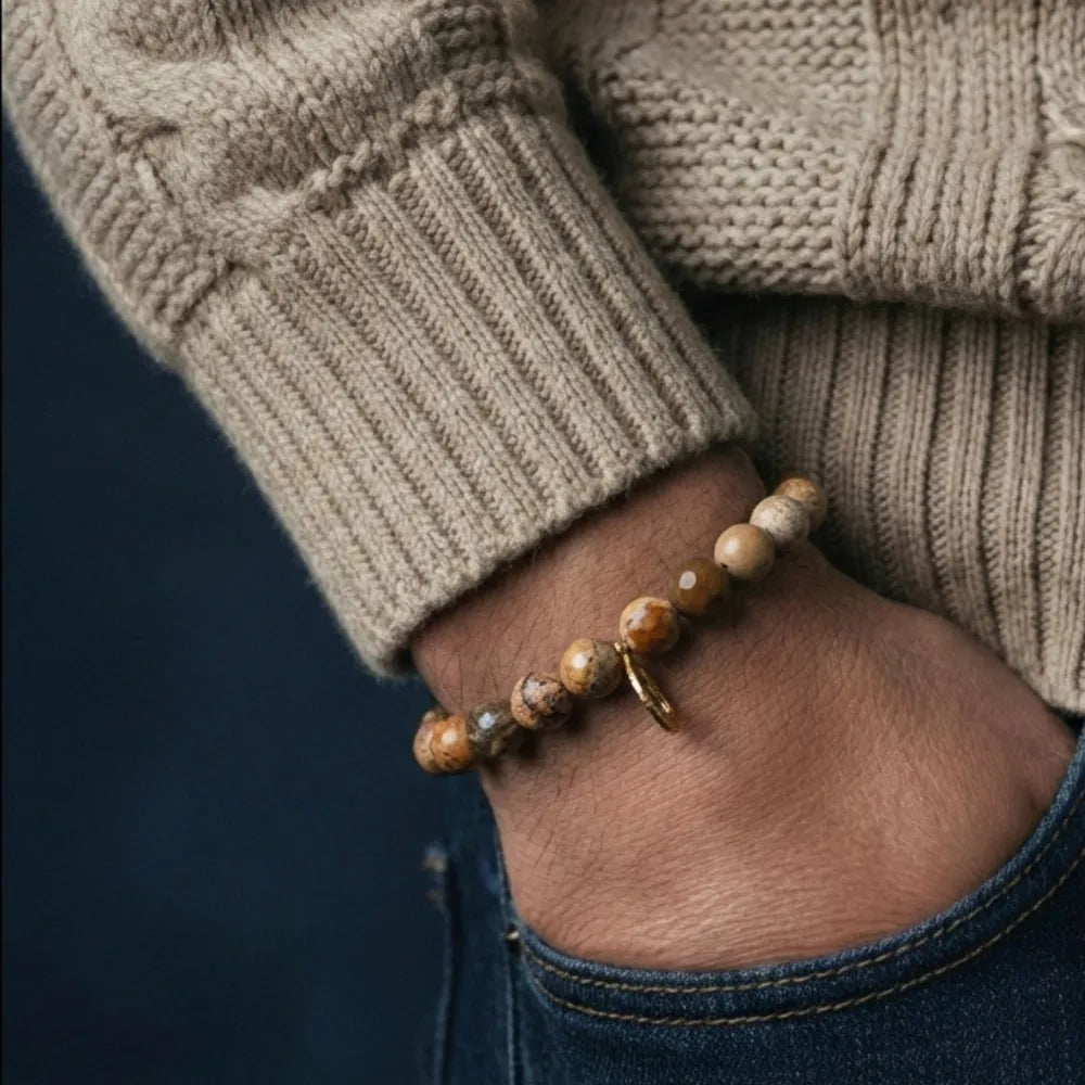 Close-up of a hand wearing a beaded bracelet with a neutral background