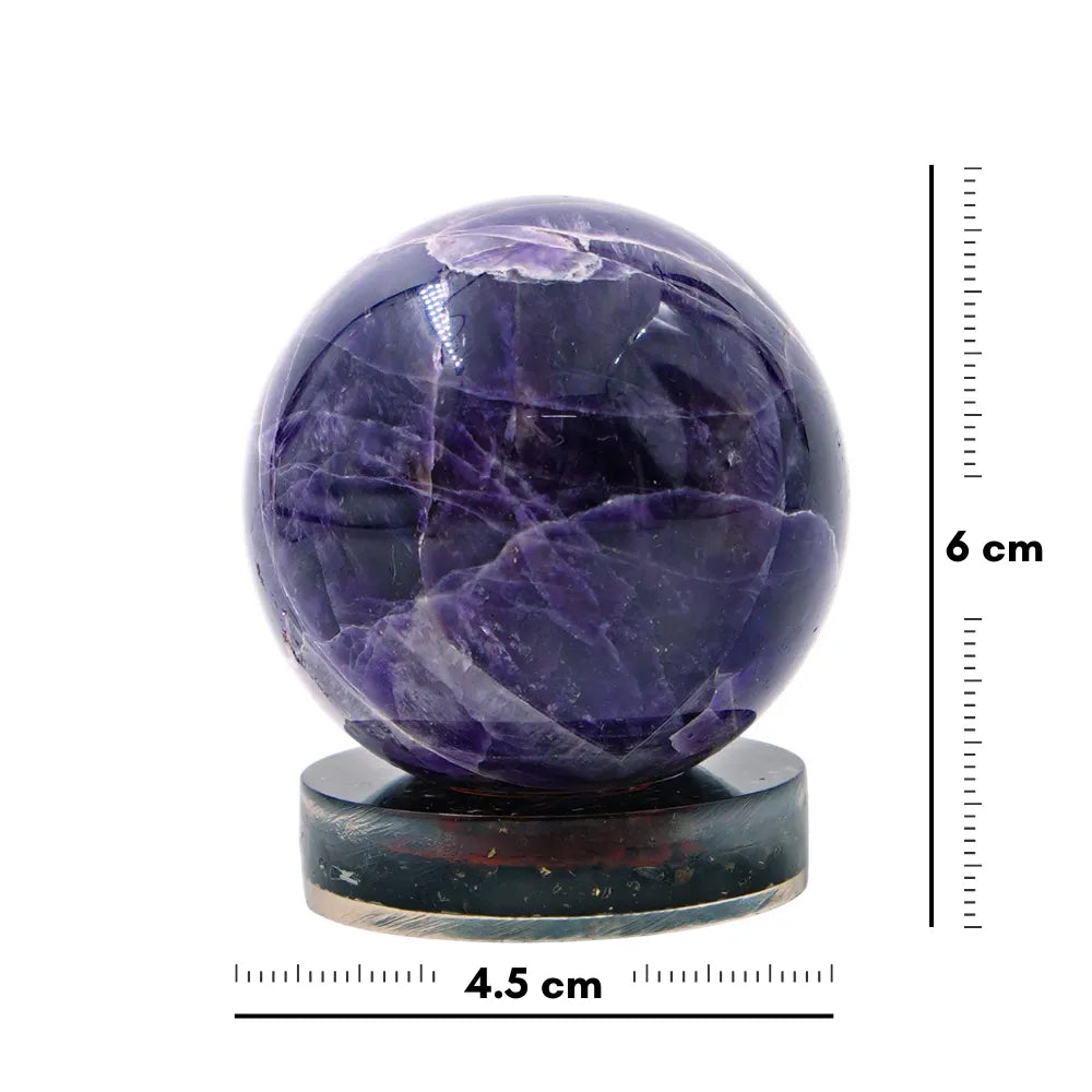 Purple crystal sphere on a stand with measurement scale
