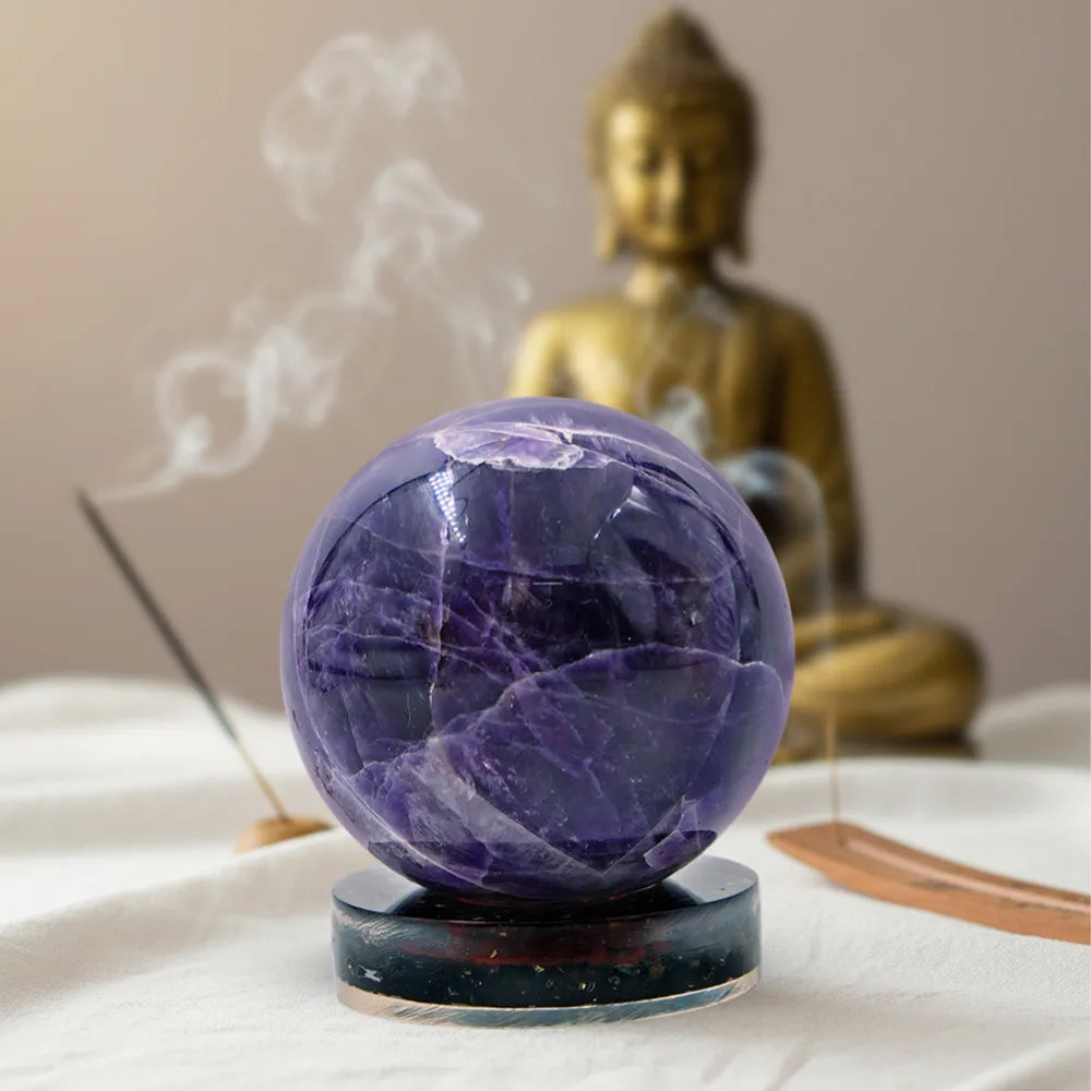 Purple crystal ball on a stand with a gold Buddha statue in the background