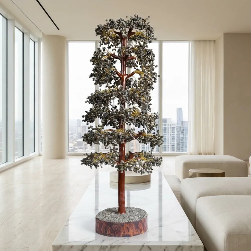 Decorative tree on a marble table in a modern living room with large windows.