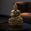 Gold Buddha statue on a reflective surface with a dark background