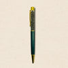Green pen with gold accents on a beige background