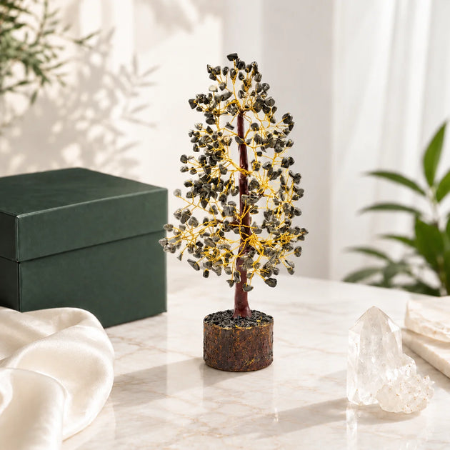 Pyrite crystal tree with metallic pyrite chips on golden wire branches, beside a gift box