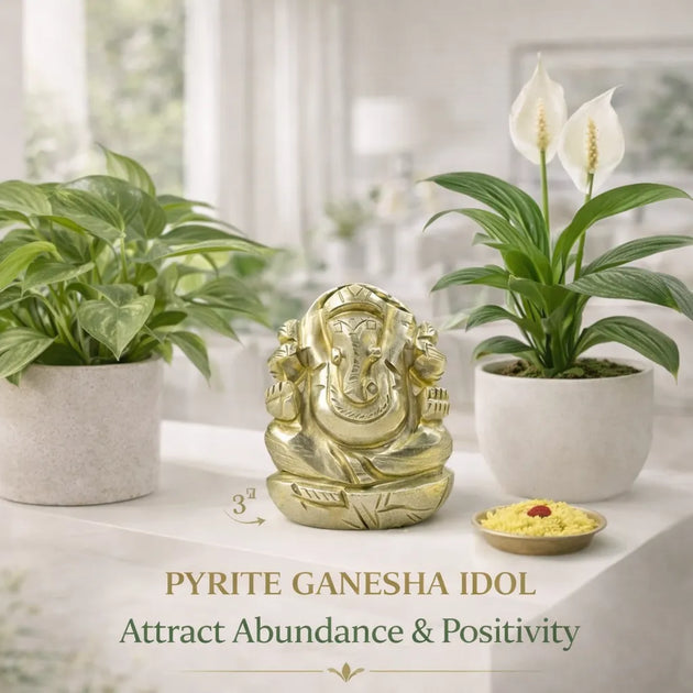 Gold Ganesha idol on a table with plants and text about attracting abundance and positivity.