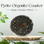 Pyrite Orgonite Coaster with text 'Cleanse, Energize, Protect' on a light background with greenery.