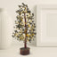  pyrite tree with black stones surrounded, wooden base, and gold wiring on a neutral background
