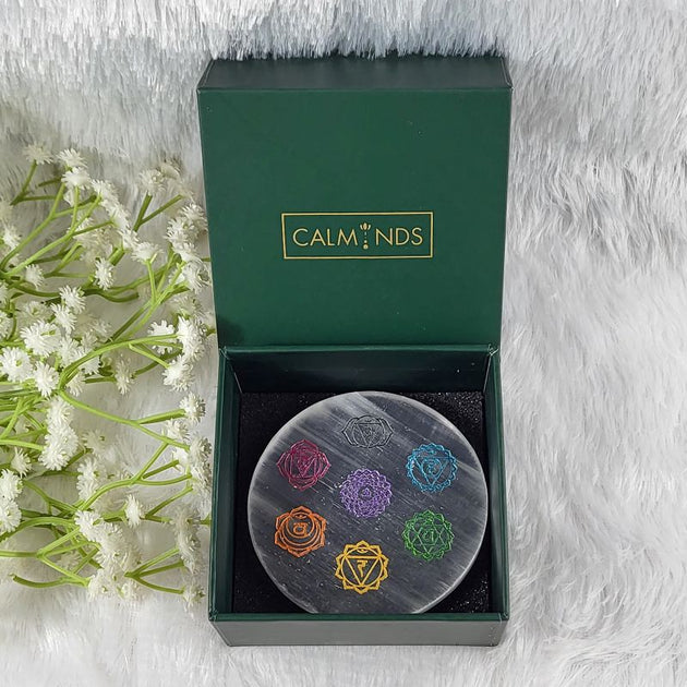Decorative stone with colorful symbols in a 'Calminds' box on a soft white background