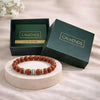 Brown beaded bracelet on a white stand with 'CALMINDS' branded box in the background.