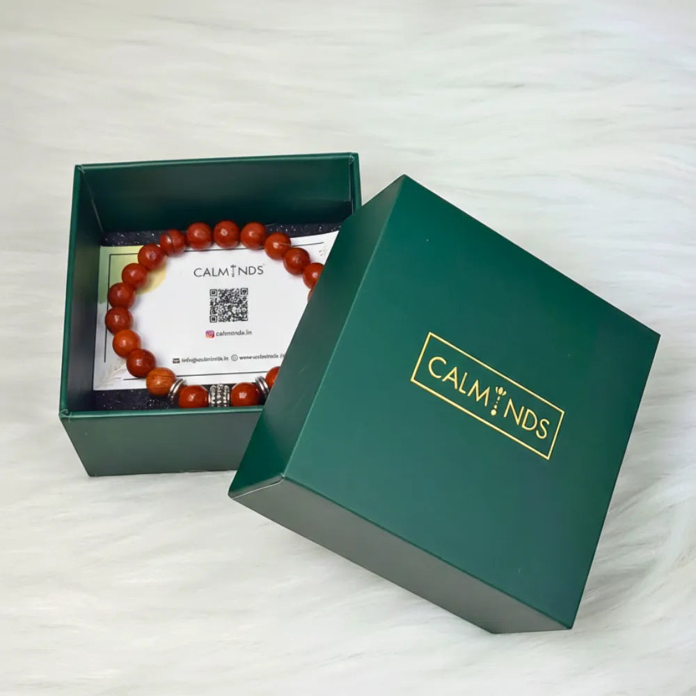 Open green box with a bracelet and card inside, branded 'CALM MINDS'.
