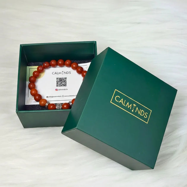 Open green box with a bracelet and card inside, branded 'CALM MINDS'.