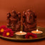 red jasper lakshmi ganesh idol pair on a golden plate with red background