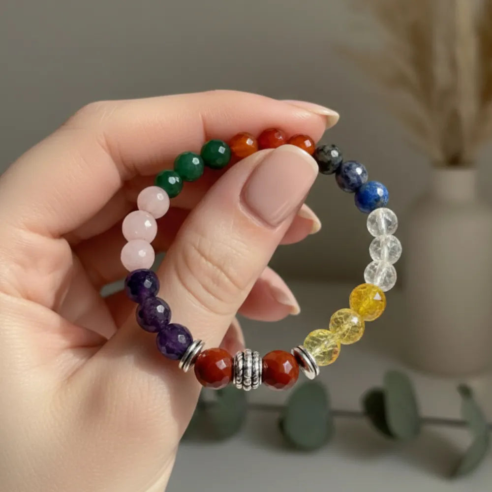 Hand holding a colorful beaded bracelet with a neutral background