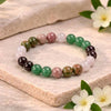 Multicolored beaded bracelet on a stone surface with flowers