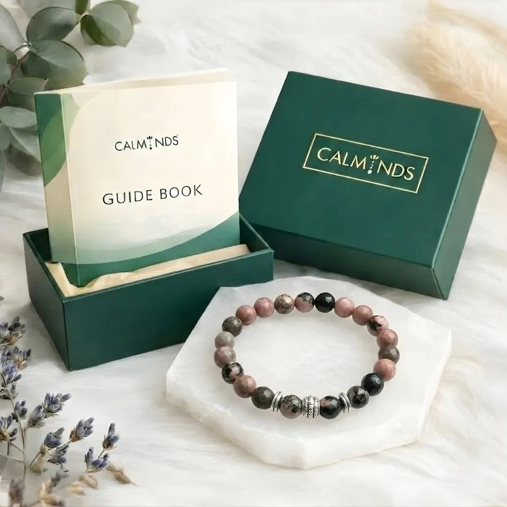 Beaded bracelet on a white surface with Calminds packaging and guide book.
