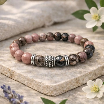 Stones bracelet on a stone surface with flowers