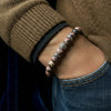 Person wearing a beaded bracelet on a blurred background