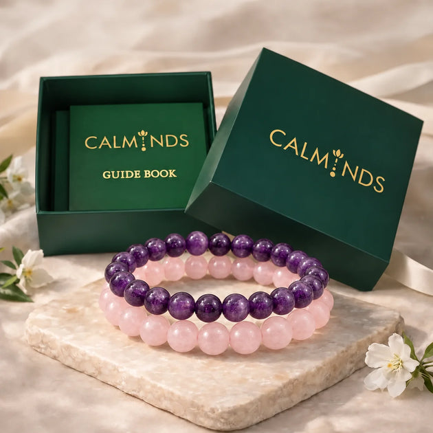 Amethyst and rose quartz bracelets in front of a Calminds gift box and guide book
