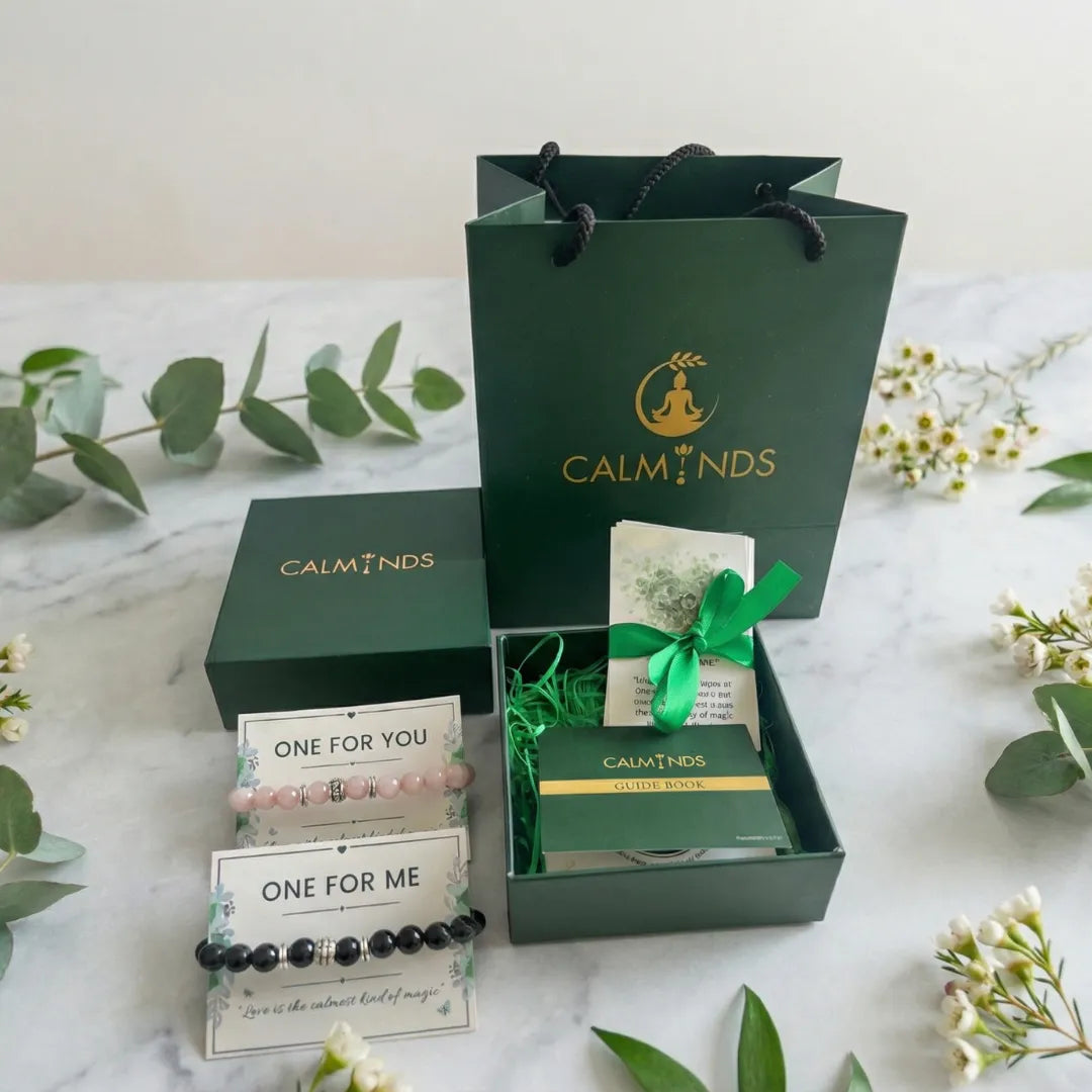 Calminds gift set with bracelets and packaging on a marble surface with greenery.