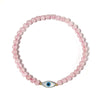 Pink beaded bracelet with a blue evil eye charm on a white background
