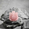 Pink stone sculpture on a gray stone surface