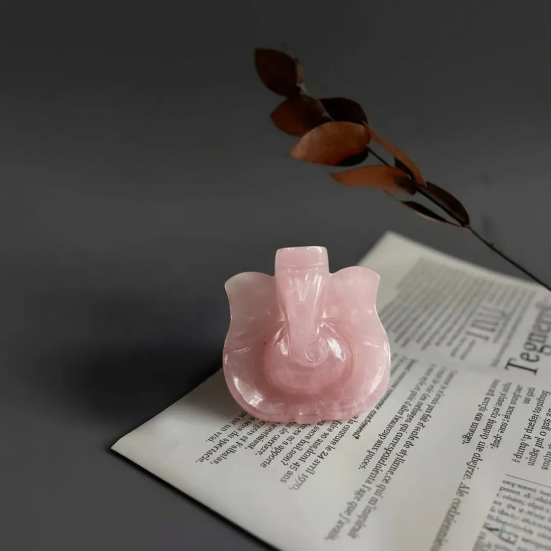 Pink ceramic object on an open book with a dark background