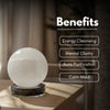 Crystal ball on a stand with benefits listed above it, in a blurred indoor setting.
