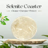 Selenite coaster on a wooden stand with plants in the background