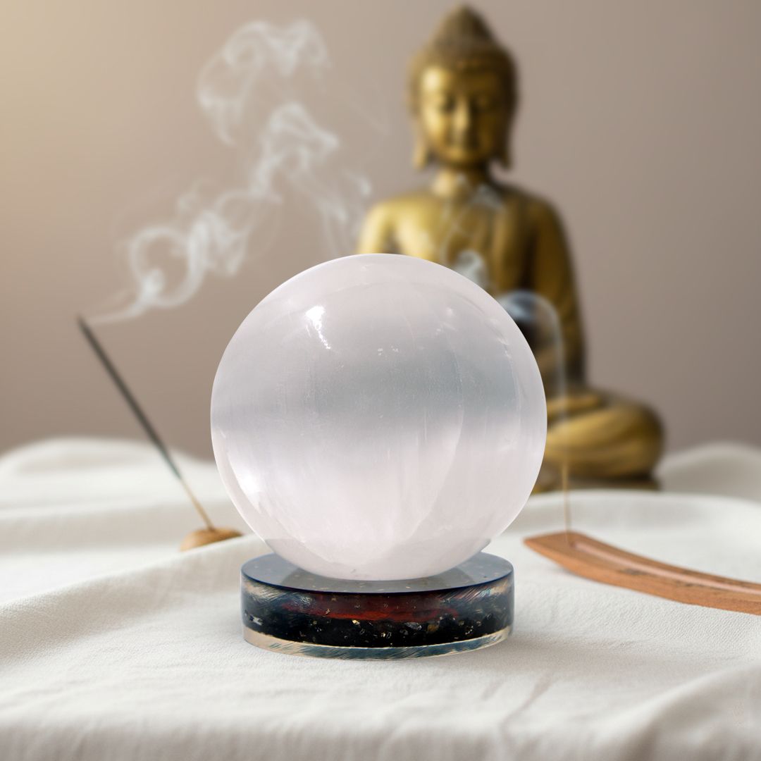 white color selenite crystal ball on a black tourmaline stand