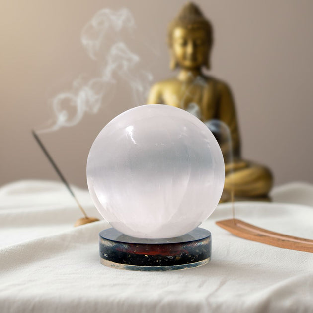 white color selenite crystal ball on a black tourmaline stand