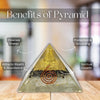 A triangular crystal pyramid with a gold-toned top, black middle band, and copper spiral detail, displayed on a wooden surface with blurred background and overlaid text reading 'Benefits of Pyramid' and callouts about energy cleansing, protection, wealth, and spiritual growth.
