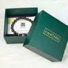 Green box with a bracelet and card inside, branded 'CALMINDS'.