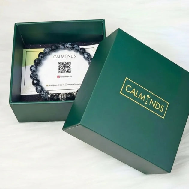 Green box with a black beaded bracelet labeled 'CALMINDS' on a white background