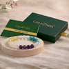 Set of colorful beaded bracelets on a wooden stand with Calminds packaging in the background.