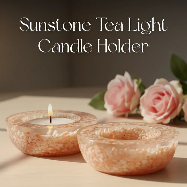 Sunstone tea light candle holder with a lit candle and pink roses on a wooden surface.
