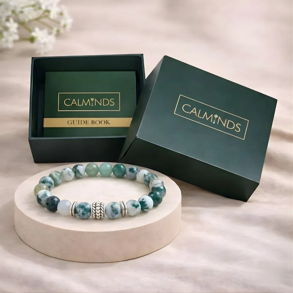 Beaded bracelet on a stand with 'CALMINDS' branded box and guide book in the background.