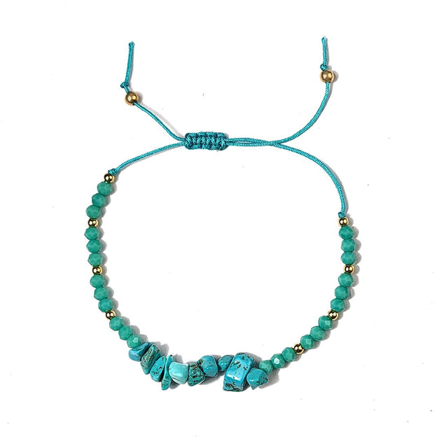 Turquoise beaded bracelet with golden thread on a white background