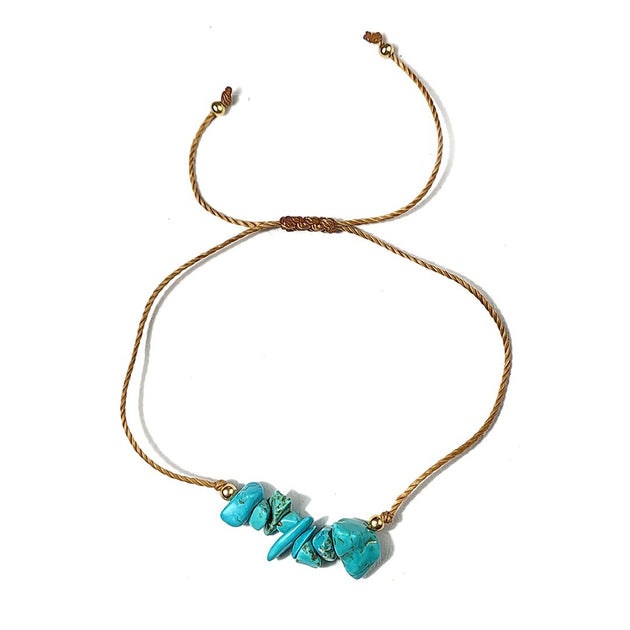 golden thread bracelet with turquoise stones on a white background