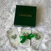 Green 'CALM NDS' box with cards and a green ribbon on a white fluffy surface