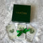 Green 'CALM NDS' box with cards and a green ribbon on a white fluffy surface