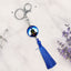 Keychain with blue tassel and decorative element on a light background